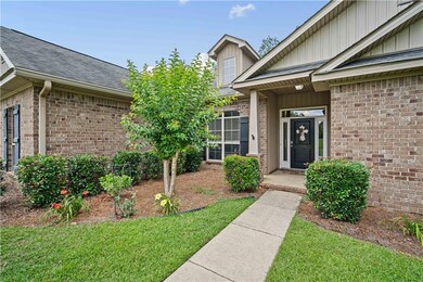 Entrance to property with brick siding, roof with shingles, and a lawn