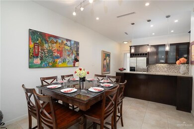 Dining area featuring light tile floors and track lighting