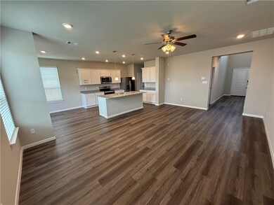Kitchen featuring white cabinetry, hanging light f