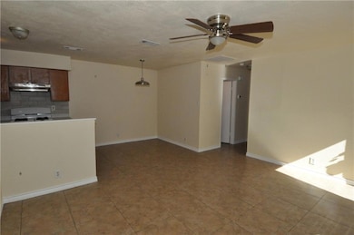 Unfurnished living room featuring a ceiling fan a