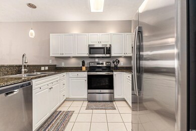 Kitchen featuring stainless steel appliances, a sink, and white cabinetry