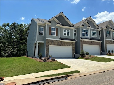 View of front facade featuring board and batten siding, an attached garage, concrete driveway, a front lawn, and stone siding