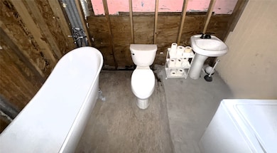 View of the full bath and laundry room combo. This