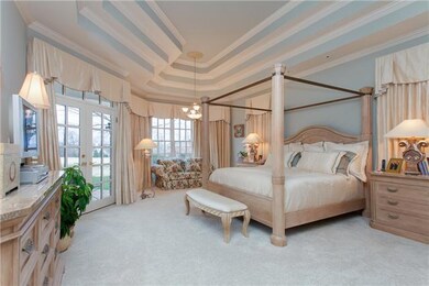 The master bedroom is wonderfully spacious, features his and her closets, French doors leading to the back, covered patio and look at those BEAUTIFUL ceilings!