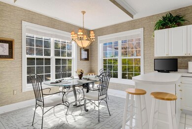 Dining room with light tile patterned floors, baseboards, a chandelier, and wallpapered walls