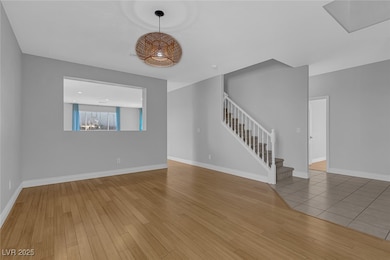 Unfurnished living room featuring stairway and woo