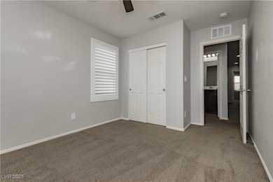 Unfurnished bedroom featuring carpet flooring, a closet, ceiling fan, and multiple windows