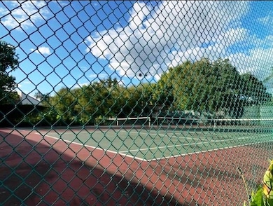 This photo shows a fenced-in tennis court surround