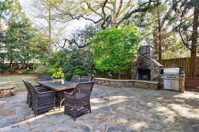 Level yard and patio with an outdoor fireplace and