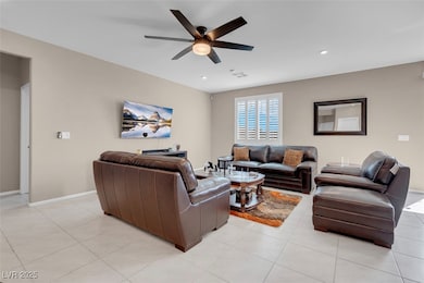 Living room featuring ceiling fan, light tile patt