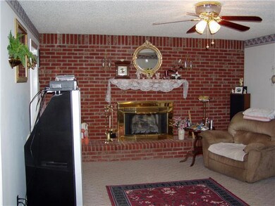 Den with brick fireplace and gas logs.