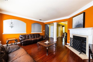 Living room featuring ornamental molding, a firepl