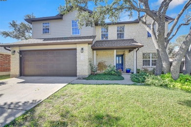 Traditional-style home featuring stone siding, concrete driveway, a porch, and a front yard
