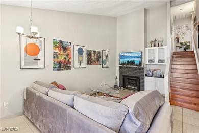 Living room with an inviting chandelier, light tile patterned floors, a fireplace, and stairway