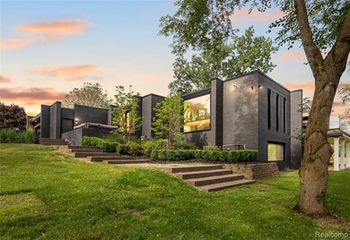 Back of house at dusk featuring a yard, brick siding, and stairway