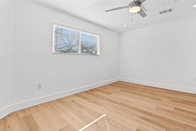 Empty room featuring a ceiling fan, light wood fi