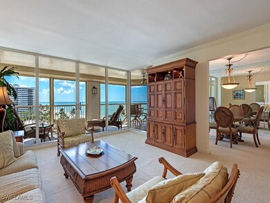 Carpeted living area with floor to ceiling windows, a water view, and crown molding