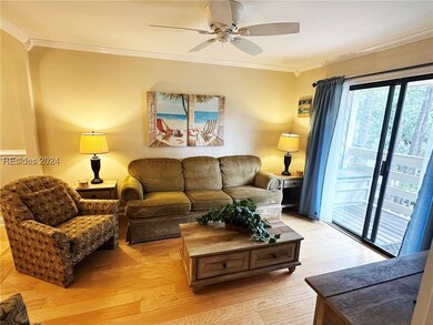 Living room featuring ceiling fan, light hardwood
