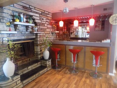 Wet bar area with wood fireplace.