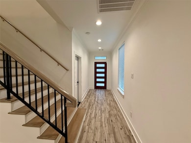 This entryway features a modern wooden staircase w