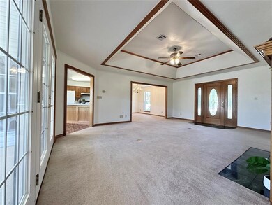 Carpeted foyer featuring ceiling fan with notable 
