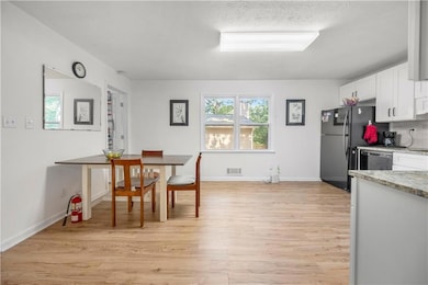 Dining room featuring light wood-type flooring and baseboards