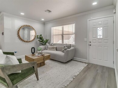 Living room featuring crown molding and light hard