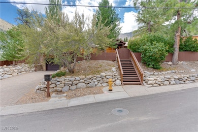 View of front of home featuring a garage, a mountain view, decorative driveway, and stairway