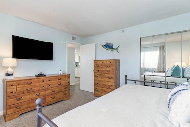 Bedroom with visible vents, a closet, a textured ceiling, and carpet floors