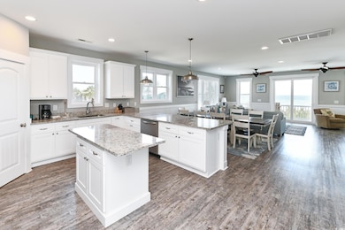Kitchen with pendant lighting, white cabinetry, wo