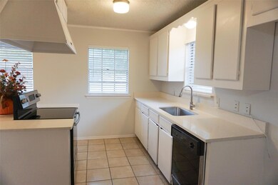 Kitchen featuring sink, ventilation hood, electric