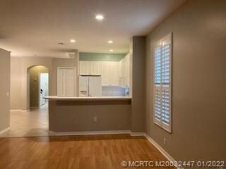 PASS THROUGH FROM THE KITCHEN TO LIVING ROOM, DINING ROOM IS TO THE LEFT SIDE OF THE KITCHEN. YOU HAVE TILE AND LAMINATE FLORRS. NEWER WHITE CABINETS, REFIG,STOVE ELEC, DISHWASHER AND MICRO WAVE.  POCKET LIGHTING IN THE CEILING. THIS VIEW LOOKS OUT OVER THE SCREENED PATIO AND THE GOLF COURSE.