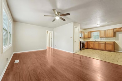Unfurnished living room featuring ceiling fan, lig