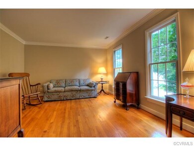 The formal living room with hardwood floors and cr