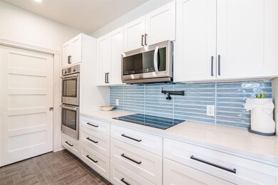 Kitchen featuring tasteful backsplash, white cabi