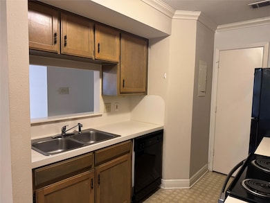 Kitchen with crown molding, light countertops, black appliances, and light flooring