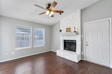 Unfurnished living room featuring lofted ceiling, a fireplace, dark wood finished floors, and ceiling fan