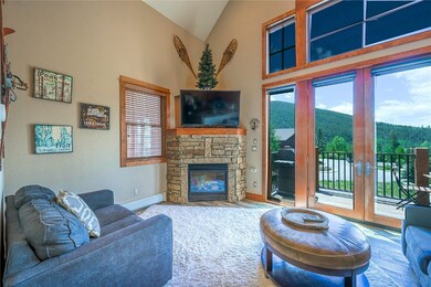 Living room with a stone fireplace, french doors,