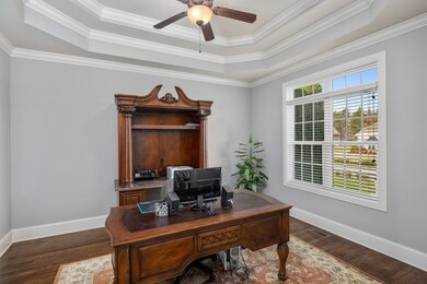 The office features a double tray ceiling, crown molding, a neutral paint palette and large windows that allow for natural light