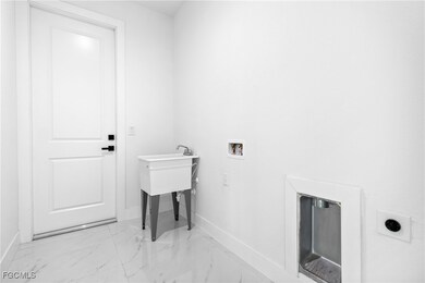 Laundry room with light marble finish floors and hookup for a washing machine