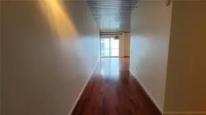 Hall with baseboards and dark wood-type flooring