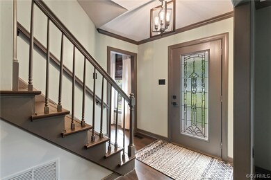 Wood floored entrance foyer with crown molding