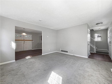 Carpeted living room featuring a textured ceiling