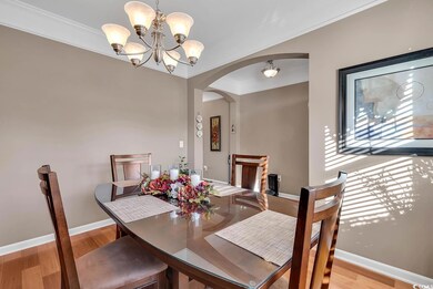 Dining area featuring crown molding, light hardwood / wood-style flooring, and a chandelier