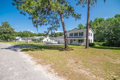View of front of home with driveway, covered porch, a front yard, and a garage
