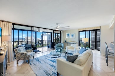 Living area featuring light tile patterned floors, ceiling fan, plenty of natural light, and a wall of windows