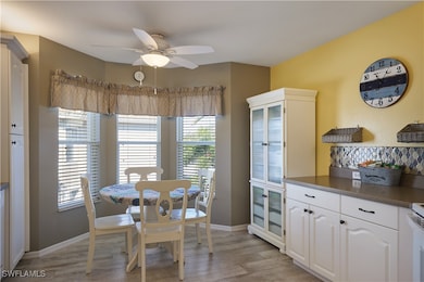 Dining area with ceiling fan and light hardwood /