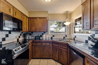 Kitchen with hanging light fixtures, tile countert