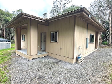 Left side of home front door, covered lanai, propane connections and breakers box in front