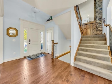 Entrance foyer featuring hardwood / wood-style floors and vaulted ceiling